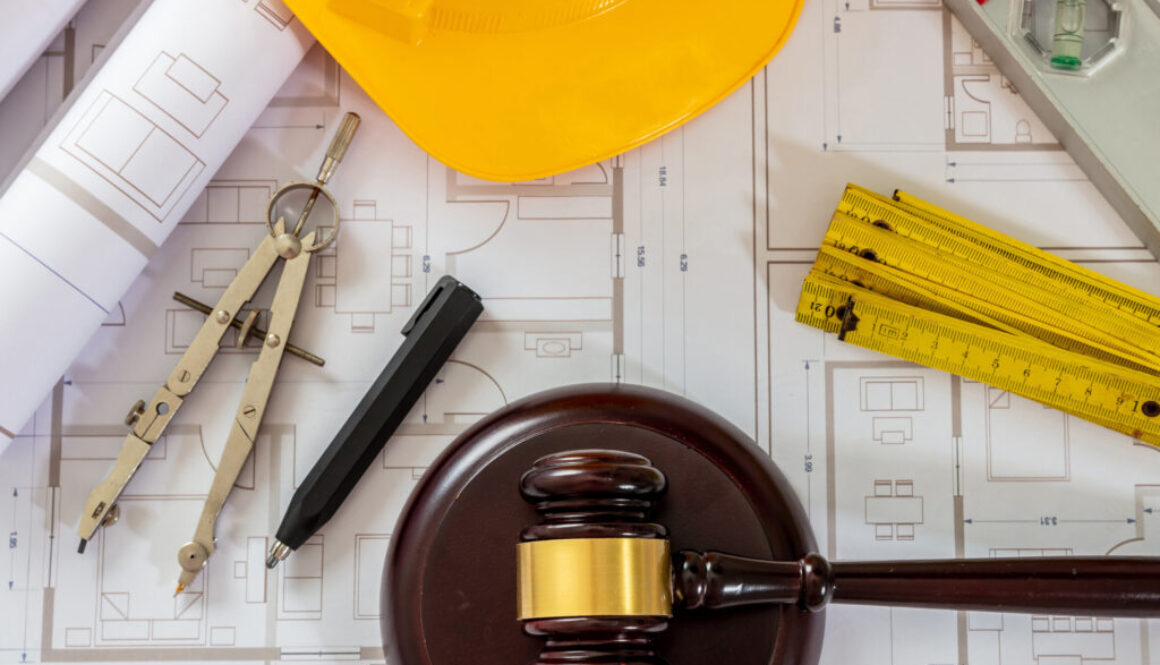 Construction and Labor law flat lay. Judge gavel and design tools on building blueprint